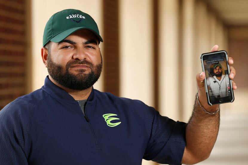 Marco Regalado holds up his phone where he posts Tik tok videos about football as he poses...