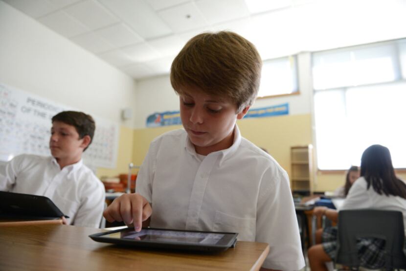 Cooper Newsom works on his iPad during Adam Willis' seventh-grade science class. Willis...