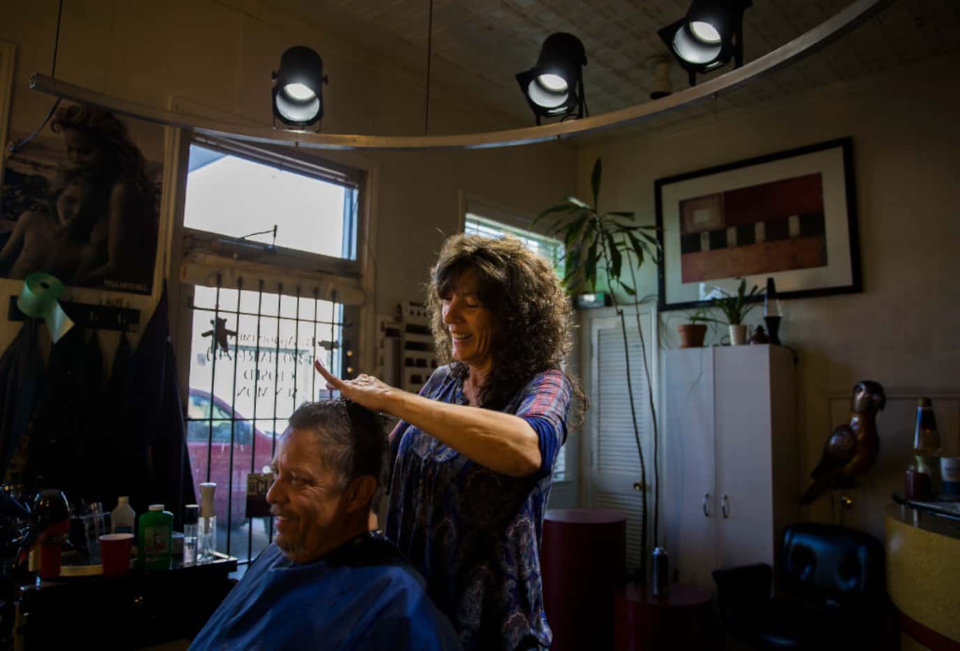 Tracey Newman, owner of Dallas Hair Company, gives a haircut to Mark Brock at her salon...