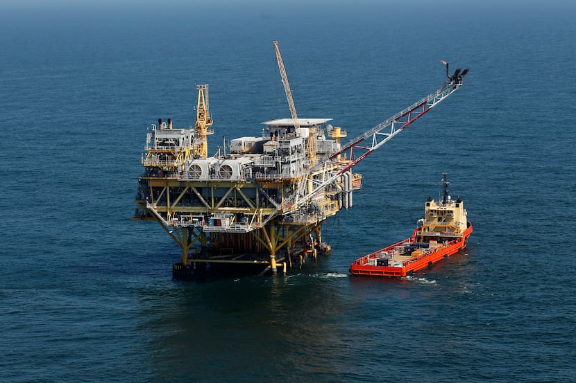 A rig and supply vessel are viewed in the Gulf of Mexico off the coast of Louisiana, April...