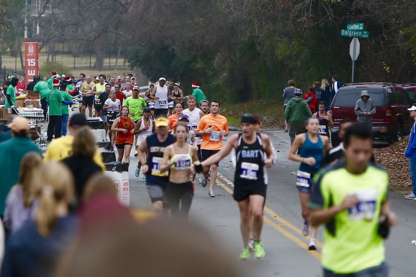 FILE - Runners pass the 15 mile marker heading north along the western banks of White Rock...