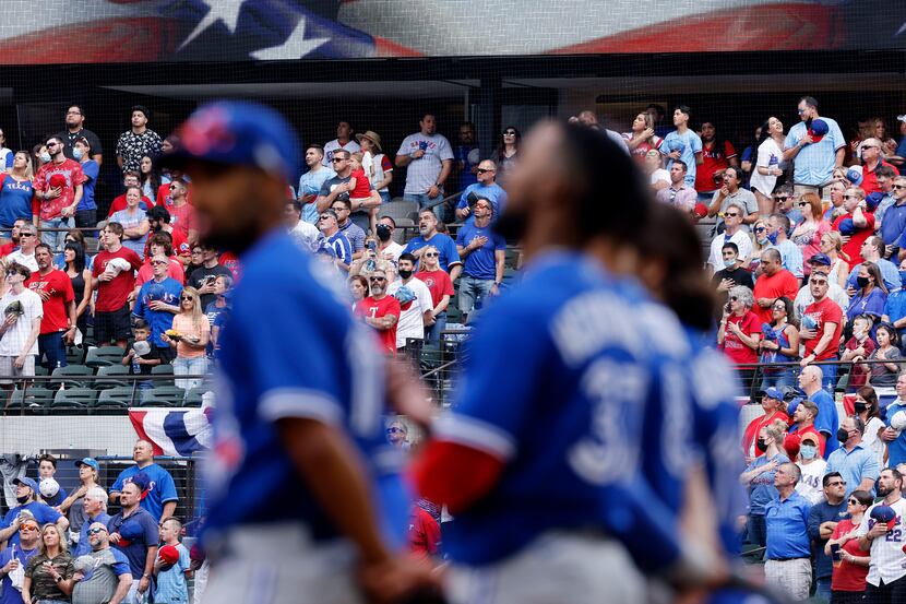 Texas Rangers fans stand and sing God Bless America in the eighth inning as the Toronto Blue...