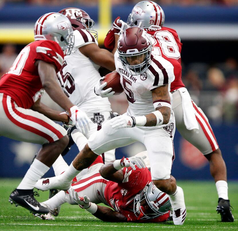 Texas A&M Aggies running back Trayveon Williams (5) is tripped up by by Arkansas Razorbacks...