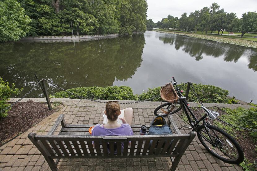 Natalie Miller enjoys a quiet moment of reading by Exall Lake in Highland Park in Dallas on...