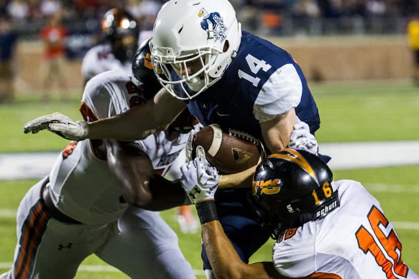 Allen wide receiver Josh Cornell (14) is tackled by Hoover linebacker Kolbe Coleman (55) and...