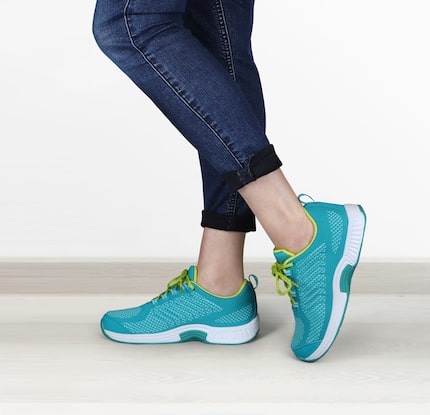 Closeup image of woman wearing turquoise Orthofeet walking shoes