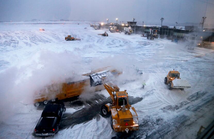 NEW YORK, NY: Front loaders dump snow into a melter while clearing the apron around Gates C...
