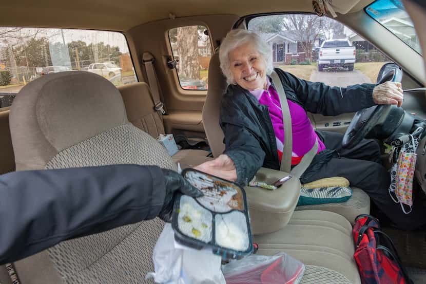 Francia De La Rosa (left), Jefferson Senior Center manager, delivers meals in a time of...