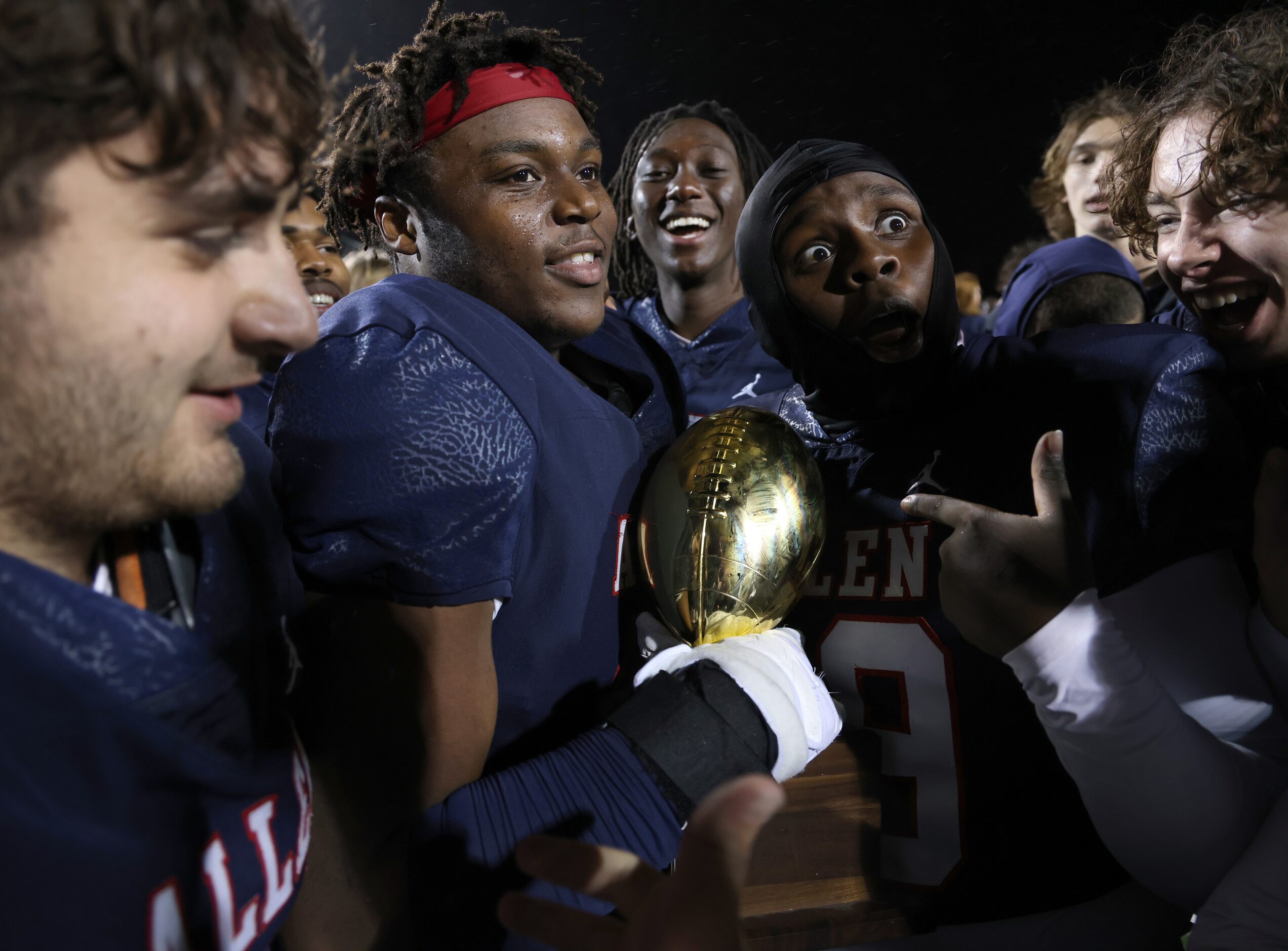 Allen Eagles players celebrate at midfield after receiving the Bi-District trophy after...