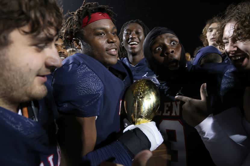 Allen Eagles players celebrate at midfield after receiving the Bi-District trophy after...