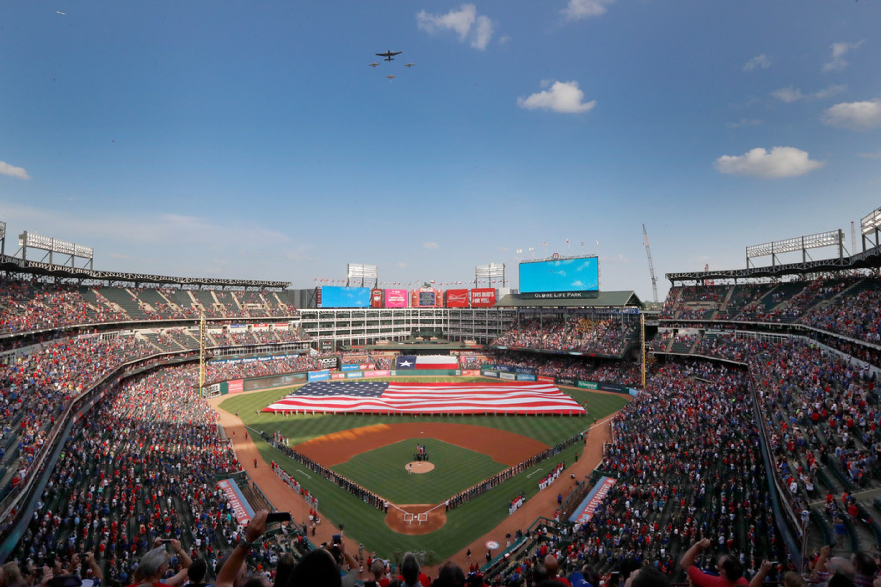 An American flag is displayed on the field as vintage military aircraft from the Cavanaugh...