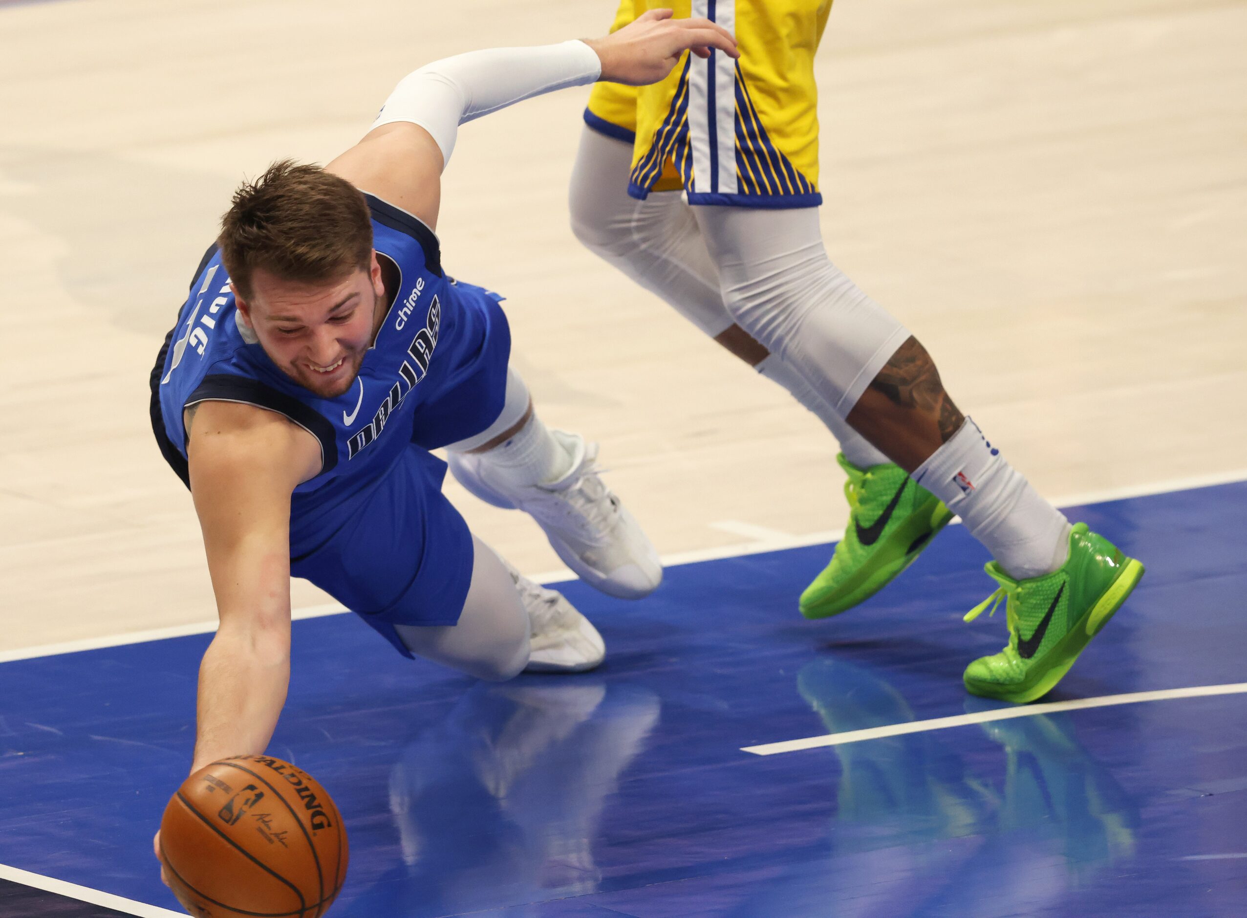 Dallas Mavericks guard Luka Doncic (77) dives for a loose ball that ended up going out of...