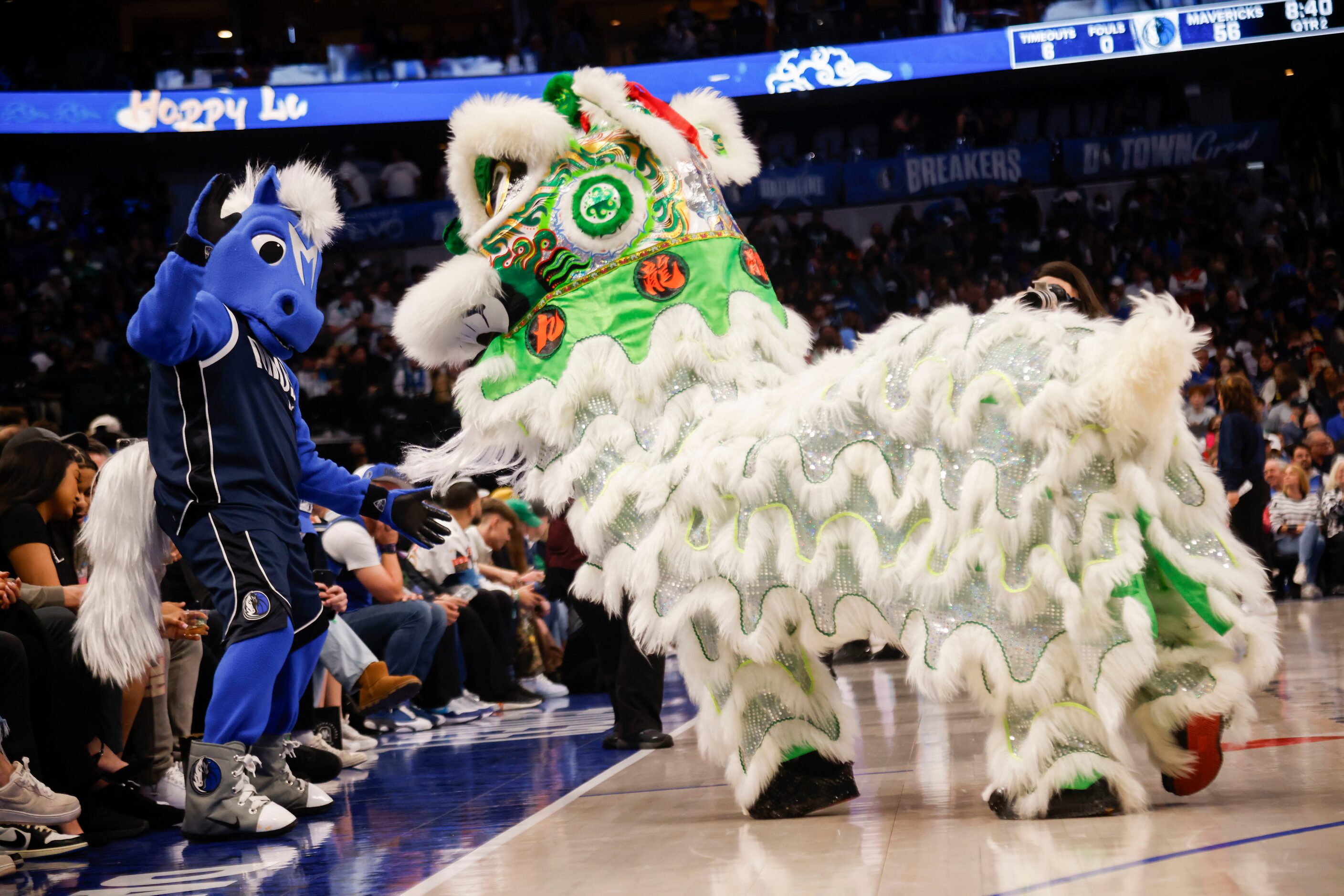 Champ dances along as lion dancers with JL Sports Association perform during a Lunar New...