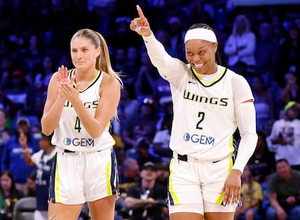 Dallas Wings guards Odyssey Sims (2) and Jacy Sheldon (4) begin to celebrate their win over...