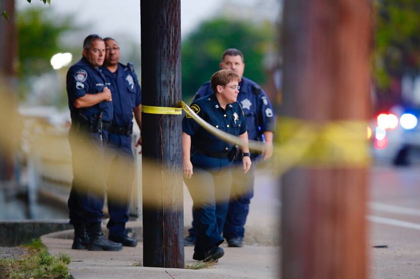 Dallas Sheriffs Deputies gather around police tape as they investigate a shooting Wednesday...