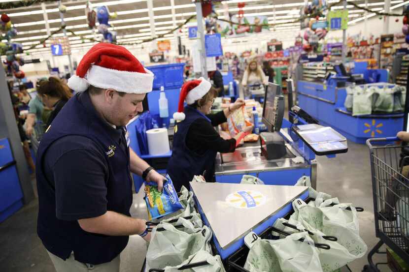 An employee places an item into a shopping bag at a Wal-Mart in Burbank, California, on Nov....