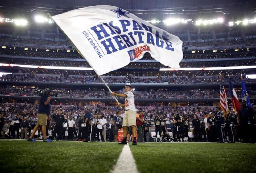 Una bandera de la NFL por el Mes de la Herencia Hispana flamea en el emparrillado del AT&T...