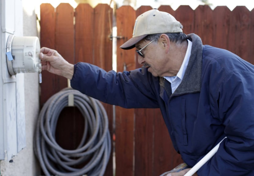 PG&E employee Art Liscano, 66, reads a meter at a house in Clovis, Calif. Every day, PG&E...