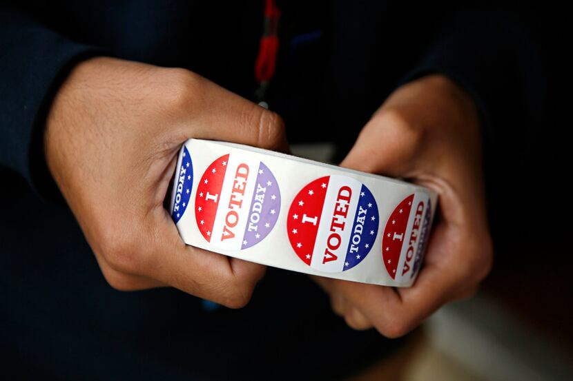 An election worker holds a roll of "I Voted Today" stickers outside of a polling place in...