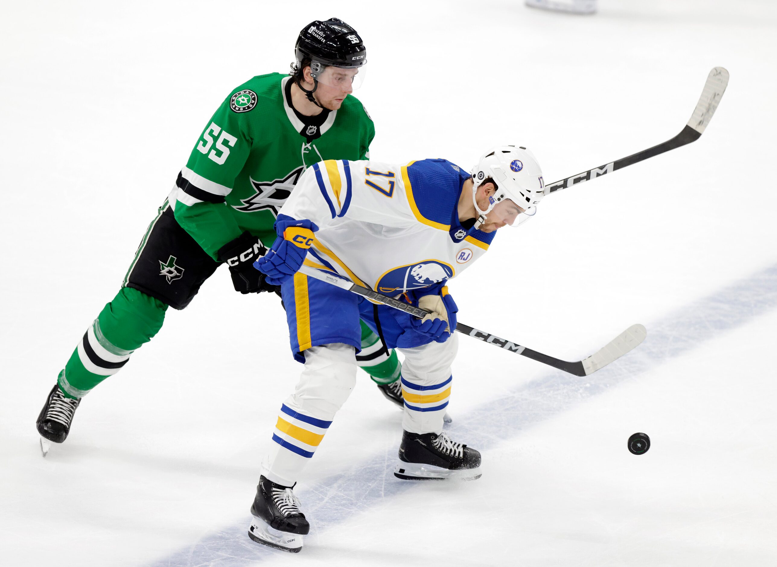 Dallas Stars defenseman Thomas Harley (55) nd Buffalo Sabres center Tyson Jost (17) battle...