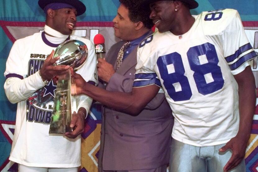 Dallas Cowboys cornerback Deion Sanders, left, and running back Michael Irvin (88) share the...