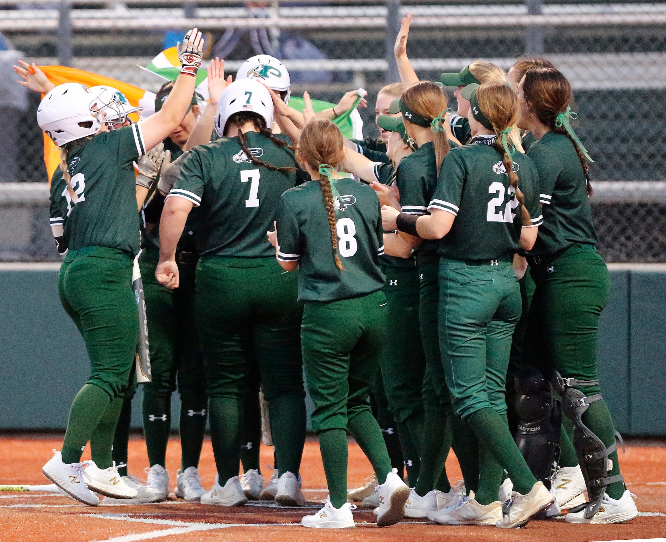 Prosper High School first baseman Sydney Lewis (7) is mobbed by team mates after hitting a...