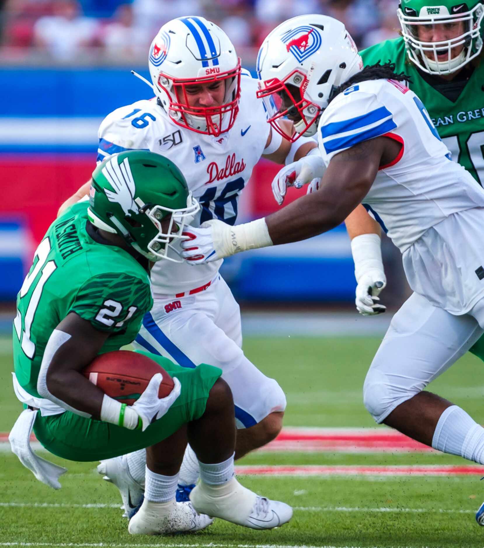UNT running back Nic Smith (21) is brought down by the facemask by SMU linebacker Shaine...