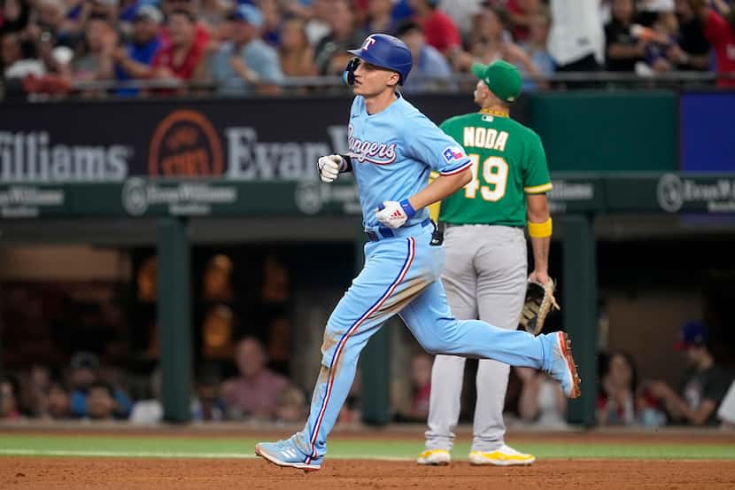 Texas Rangers' Corey Seager, front, rounds first past Oakland Athletics first baseman Ryan...