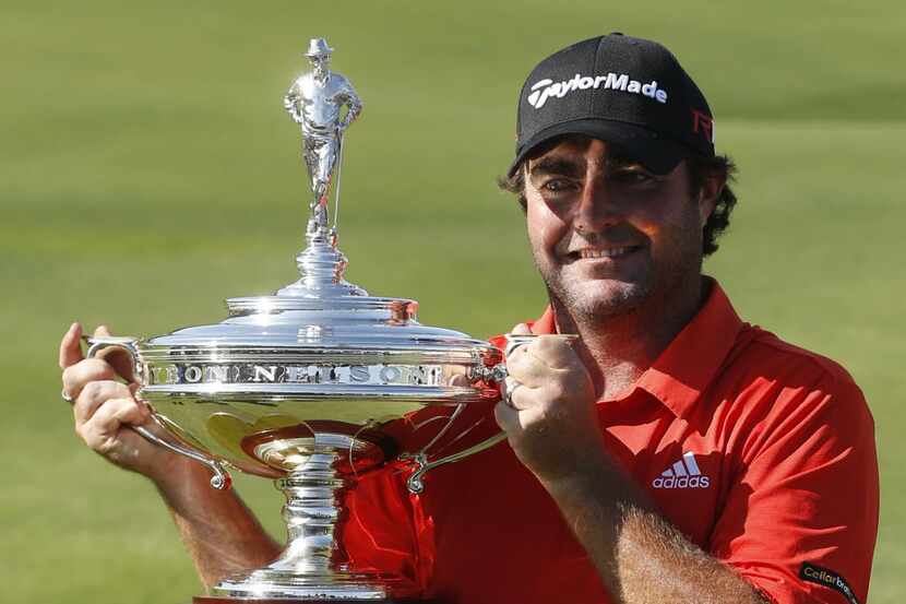 Steven Bowditch holds up the trophy for photographers after winning the AT&T Byron Nelson at...