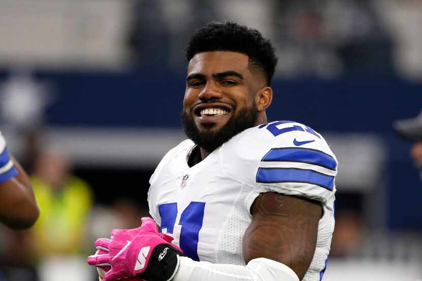 Dallas Cowboys' Ezekiel Elliott smiles as he talks with teammates during warm ups before an...