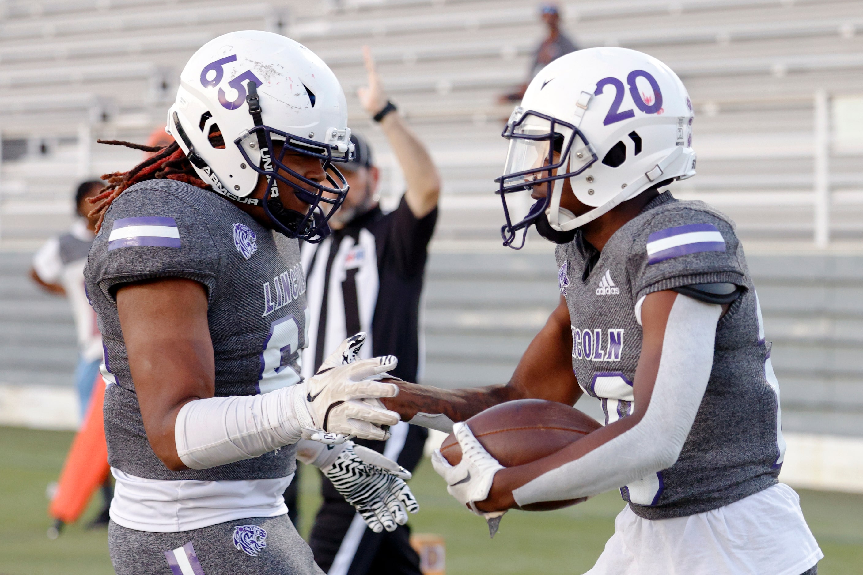 Lincoln running back Jaimirian Robertson (20) celebrates his touchdown with guard Kaiden...