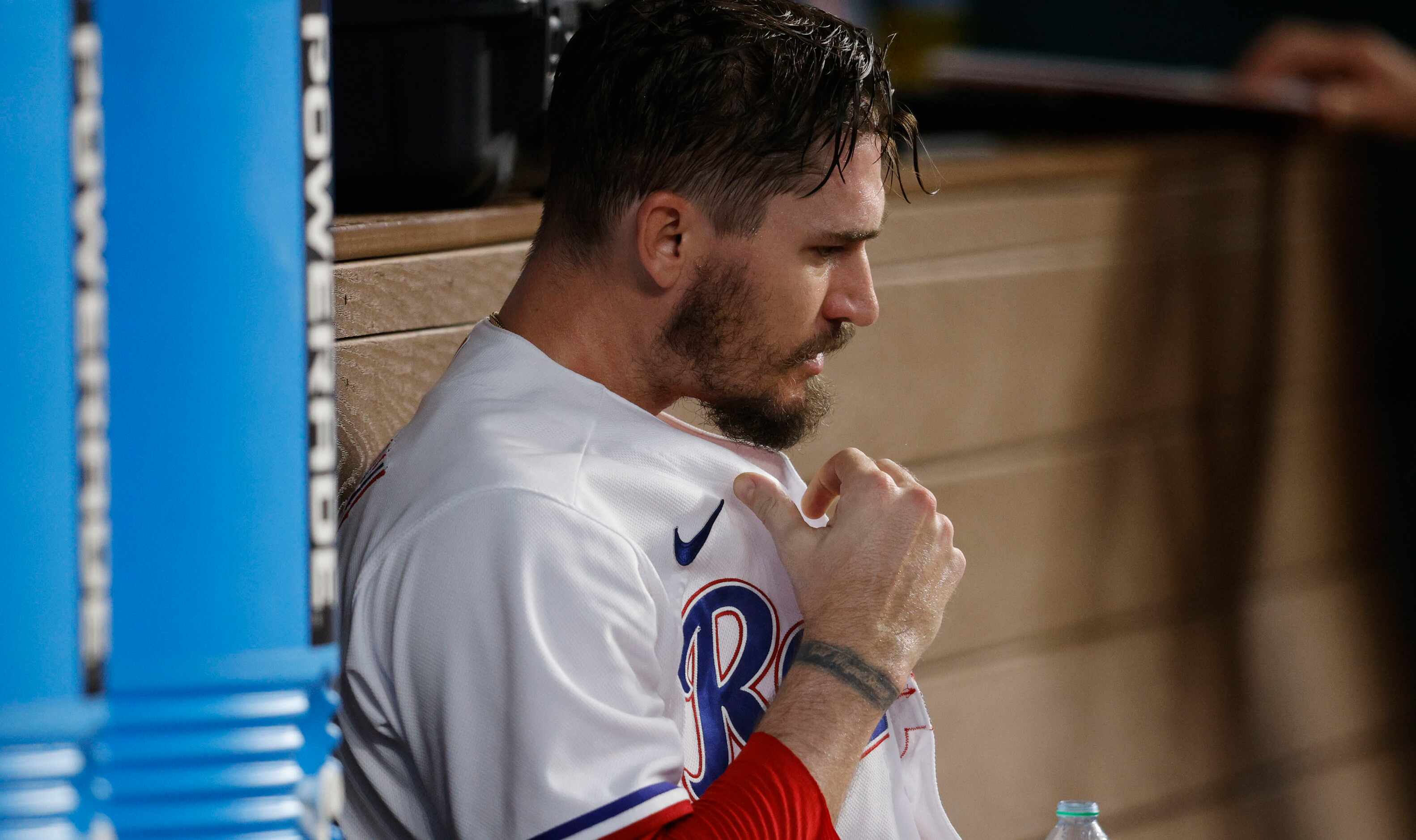 Texas Rangers starting pitcher Andrew Heaney (44) sits in the dugout after leaving the field...