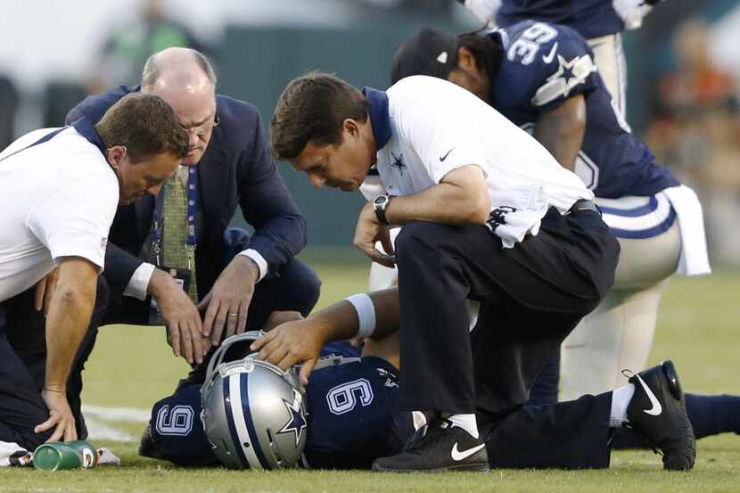Dallas Cowboys quarterback Tony Romo (9) is tended to by Dallas Cowboys medical staff after...