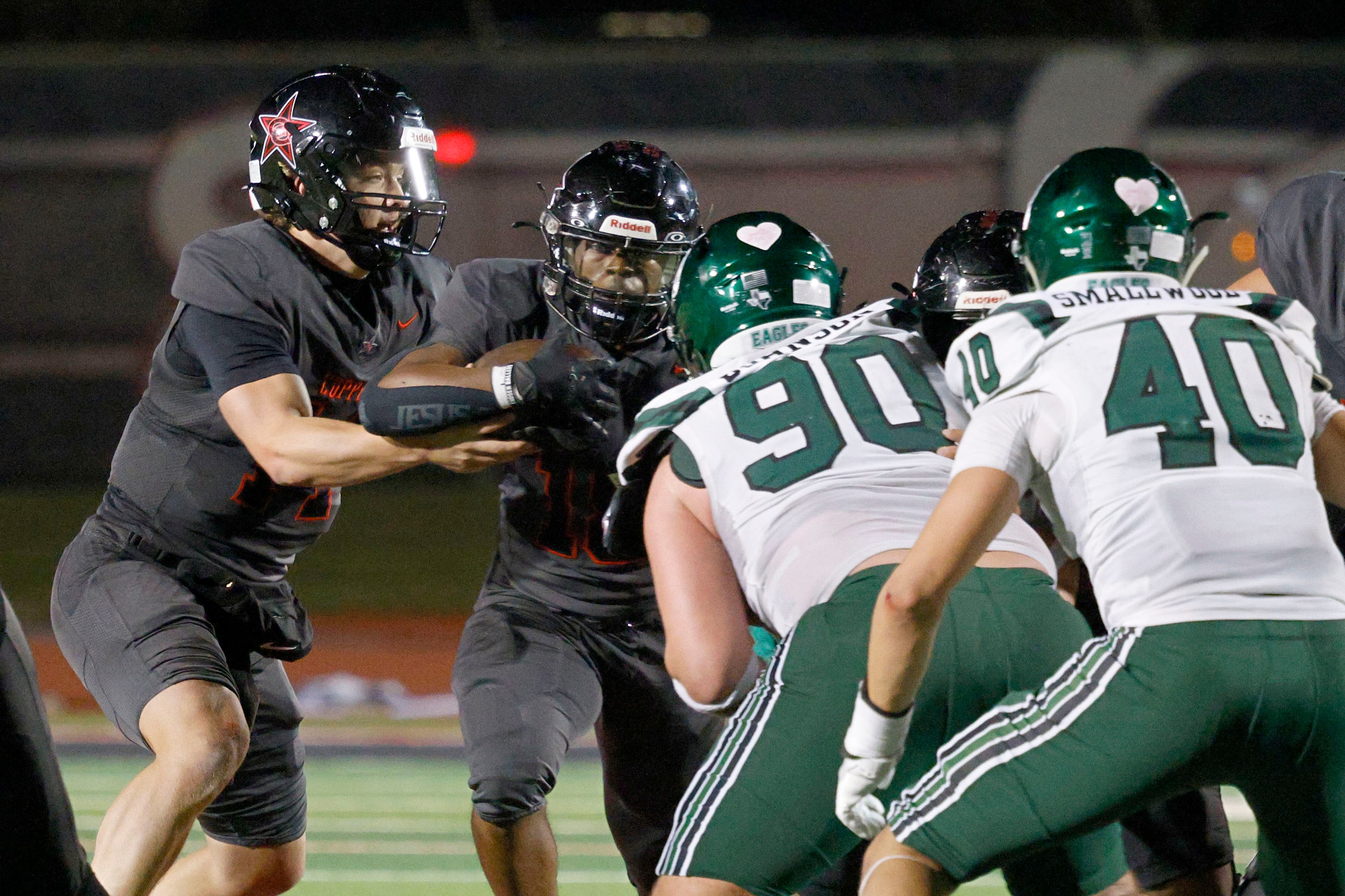 Coppell's quarterback Edward Griffin (14) hands off to Coppell's Josh Lock (18) under...