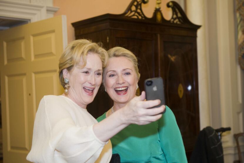 Actress Meryl Streep uses her iPhone to take a photo of her and Secretary of State Hillary...