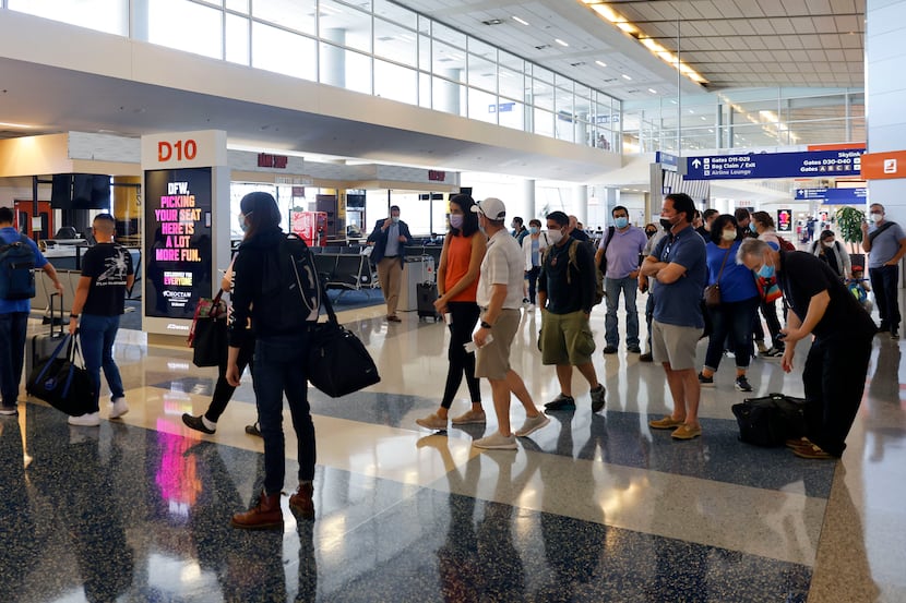 Passengers board a flight to Phoenix in Terminal D at Dallas-Fort Worth International...