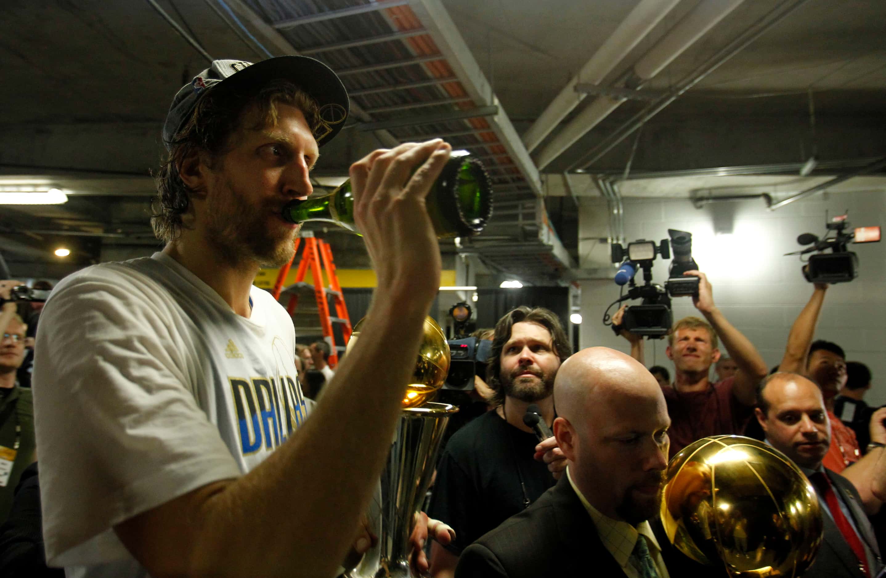 Dallas Mavericks power forward Dirk Nowitzki (41) drinks champagne as he is escorted to...