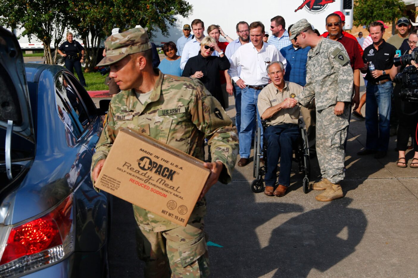 Texas Governor Greg Abbott shakes hands with Lt. Nathan Matthews (right) with the First...