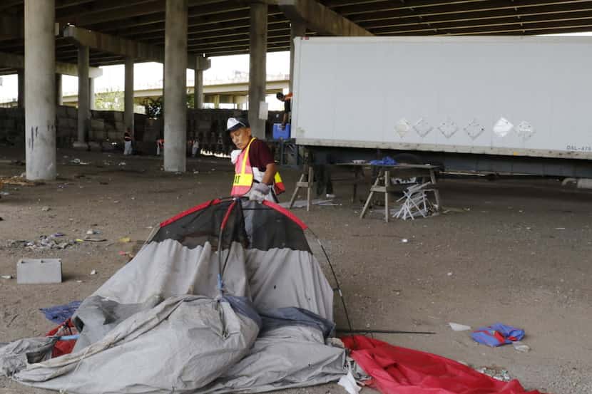 Agustin Alvarado picks up trash at a homeless encampment at Coombs Street under Interstate...