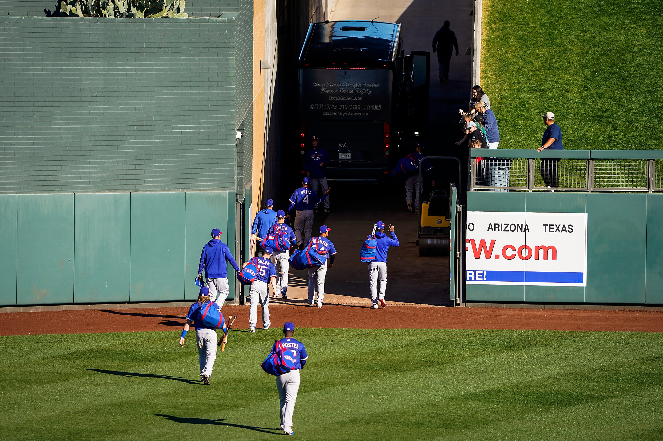 Texas Rangers players head to the team bus after a 4-3 loss to the Colorado Rockies in a...