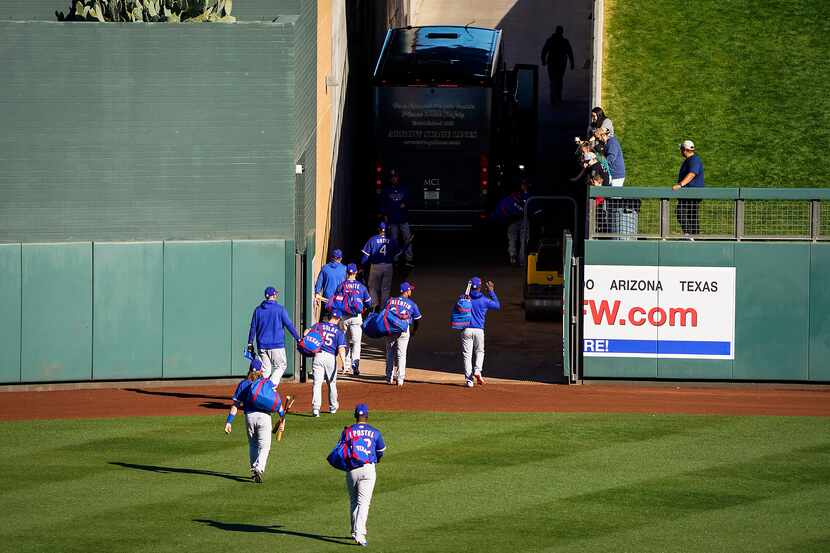 Texas Rangers players head to the team bus after a 4-3 loss to the Colorado Rockies in a...