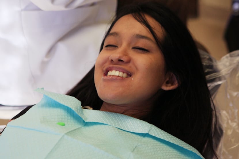 Robina Rayamajhi smiles while having a temporary crown installed by Dr. Philip Kozlow in...