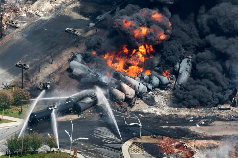 FILE - This July 6, 2013 file photo shows smoke rising from railway cars carrying crude oil...