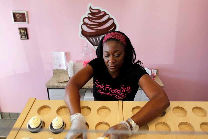  Antoinette Lafayette, owner of Pink Frosting Cupcakes in Coppell, places finished cupcakes...