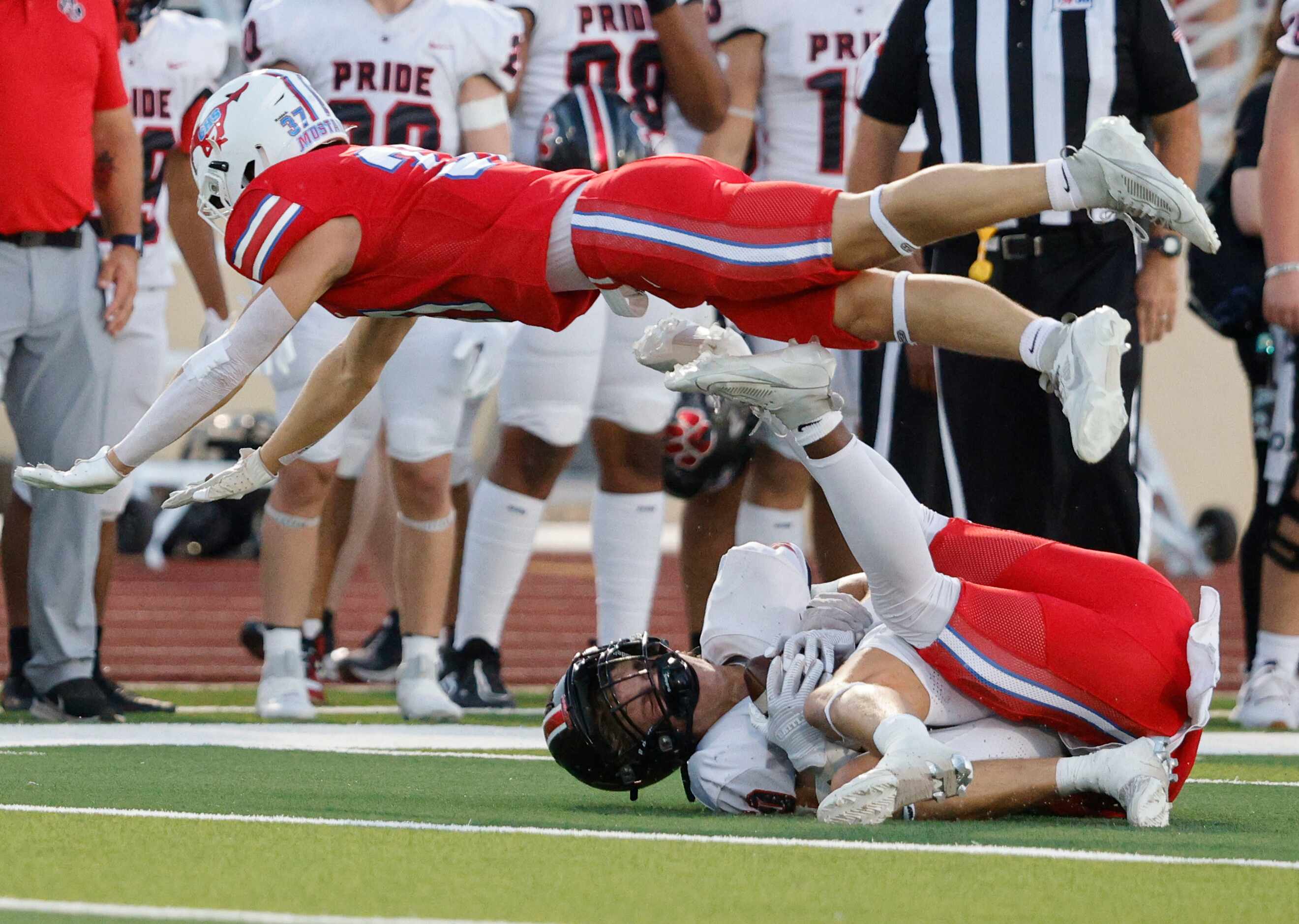 Grapevine's Maddox Stanley (37), top, tangle with Colleyville Heritage's Kai Pruitt (10)...