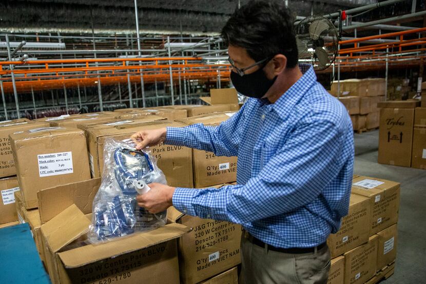 Michael Chen opens a box of the Craft & Soul face masks held in storage at Trybus Corp.'s...