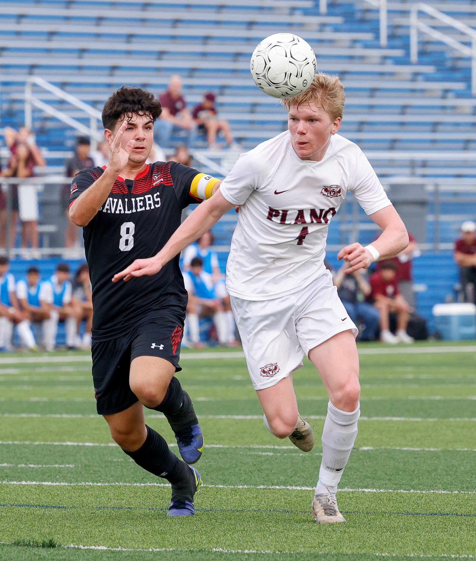 Plano midfielder Steven Wood (4) heads the ball away from Austin Lake Travis midfielder Ben...