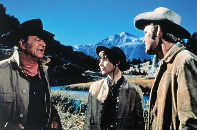 John Wayne, left, Kim Darby, center, and Glen Campbell are shown in a scene from, "True...