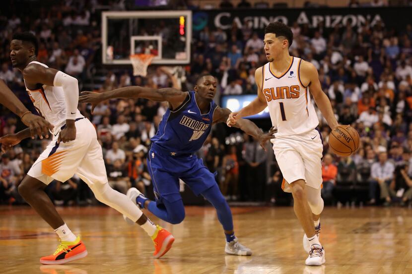 PHOENIX, AZ - OCTOBER 17:  Devin Booker #1 of the Phoenix Suns moves the ball past Dorian...
