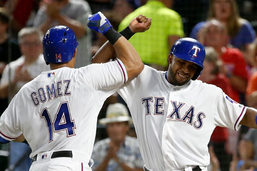 Rangers left fielder Carlos Gomez (14) is congratulated by shortstop Elvis Andrus for his...